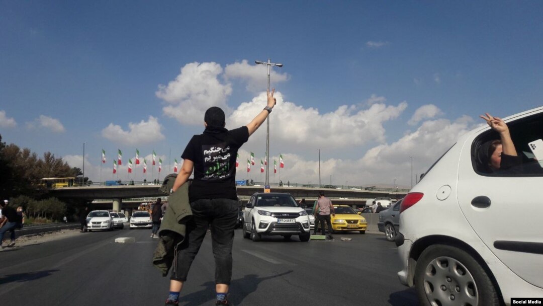 An Iranian protester stands in the highway from Tehran to Karaj on November 3.