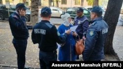 Activist Bibigul Imanghalieva speaks with police in Almaty on October 25. 