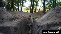 Украинский военнослужащий проверяет окопы, вырытые российскими солдатами