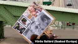  Протестиращ носи афиш на Виктор Орбан с съветския президент Владимир Путин 