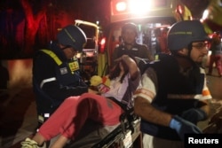 Israeli emergency responders attend to a person after Iran launched missiles into Israel, in Tel Aviv.