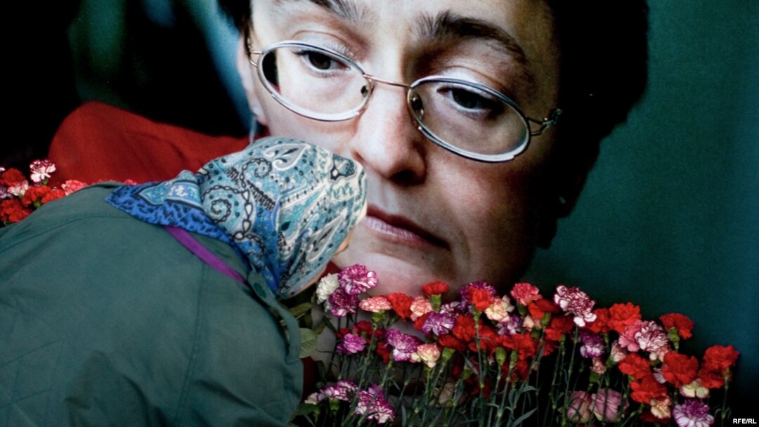 A woman lays flowers at the apartment building where journalist Anna Politkovskaya was slain in October 2006. (file photo)