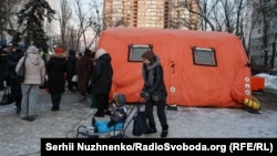 Мабільны пункт абагрэву, дзе жыхары Кіева могуць сагрэцца, папіць гарбаты, падсілкаваць тэлефоны і атрымаць дапамогу падчас адключэньня электрычнасьці і ацяпленьня. Дняпроўскі раён, Кіеў, 20 студзеня 2026 году