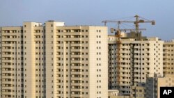 This July 6, 2019 photo shows residential towers in District 22, that consists of apartment high-rises and shopping malls arranged around an artificial lake called Chitgar, under construction on the northwestern edge of Tehran, Iran (AP Photo/Ebrahim Noro