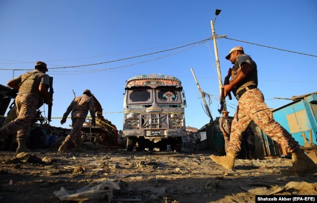 Zyrtarët e sigurisë pakistaneze në vendin e ngjarjes ku ndodhi një shpërthim në një autobus pasagjerësh në Karaçi më 20 tetor.(epa-EFE/Zaib Akber)