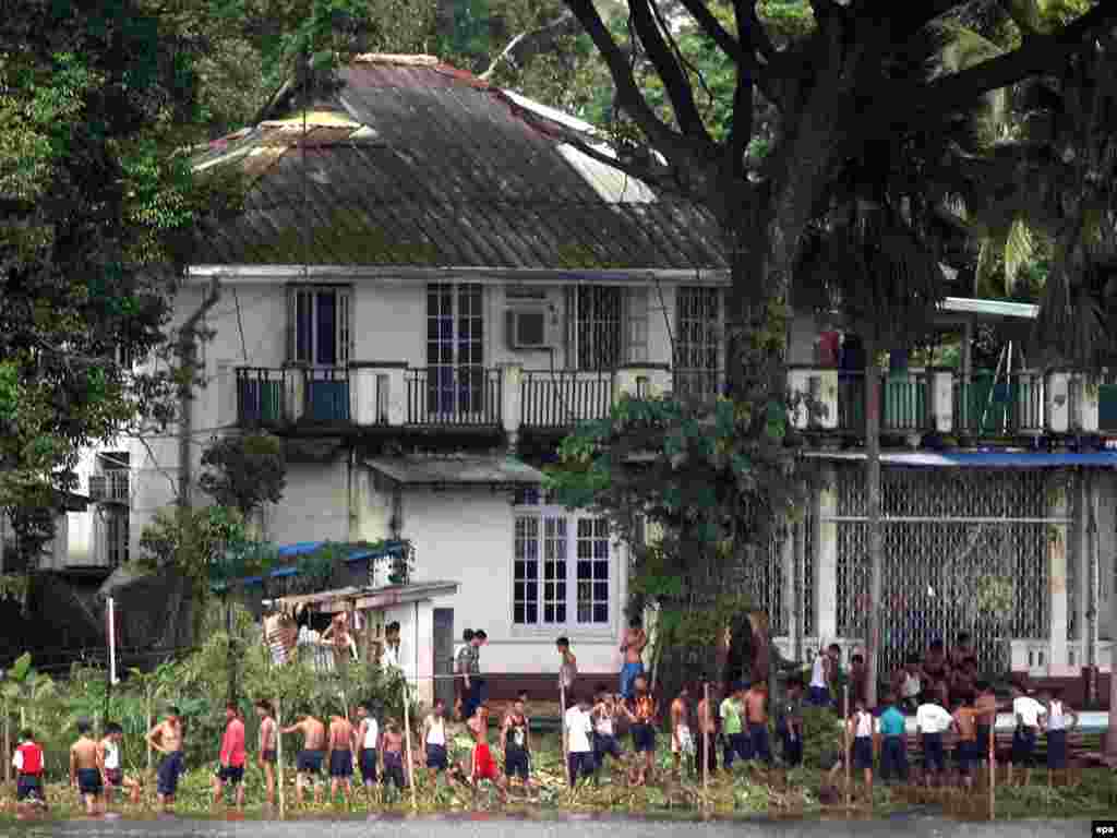 Ogradom na opoziciju - Bezbednosne snage Mjanmara postavljaju ogradu oko kuće opozicione liderke i dobitnice Nobelove nagrade za mir Aung San Su Ći, 12. avgust. Sud u Mjanmaru osudio je opozicionu liderku, Aung San Su Ći na 18 meseci kućnog pritvora, a Amerikanca Džona Jetau na sedam godina zatvora uključujući i četri godine prinudnog rada, zbog neovlašćenog ulaska u kuću nobelovke dok je bila u kućnom pritvoru. Sud je zapravo Su Ći osudio na tri godine zatvora, ali je vođa vojne hunte sudsku odluku odmah preinačio na 18 mjeseci pritvora, sasvim dovoljno da je onemogući da učestvuje na izborima iduće godine. Jetauu je presuda na kraju preinačena u uslovnu kaznu