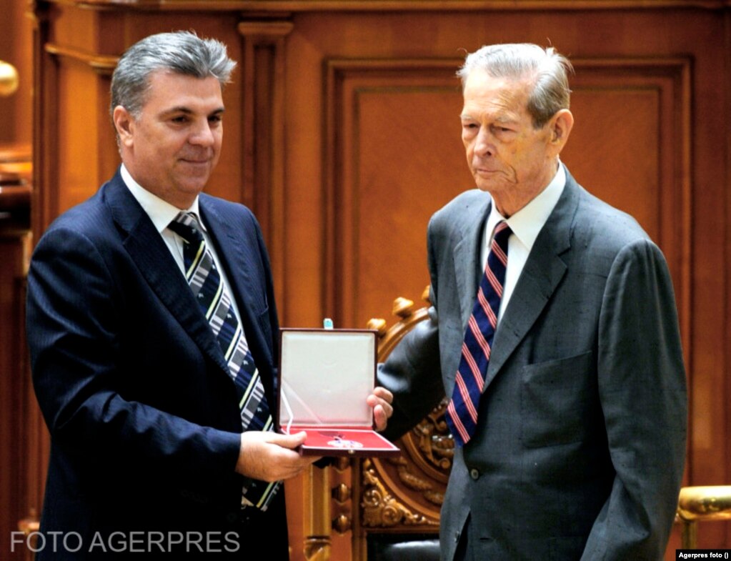 În 2011, clasa politică nu doar că nu mai refuză prezența Regelui, dar chiar încearcă să se folosească de imaginea sa, spune istoricul Dorin Dobrincu. Aici, momentul în care Valeriu Zgonea (stânga), vicepreședintele Camerei Inferioare a Parlamentului, i-a smuls Regelui Colanul Camerei Deputaților, pe care abia i-l înmânase, ca să facă ședința foto cerută de fotoreporteri, dar care nu-l avea pe el în centrul ei.