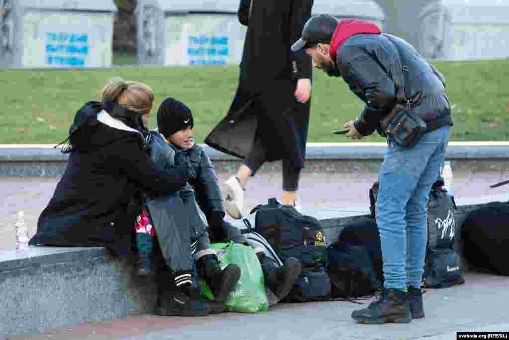 Людзі сядзяць тут групамі з валізкамі, часам зь дзецьмі, проста на лаўках, парапэтах і асфальце па некалькі гадзін.