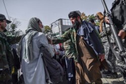 یکی از اعضای طالبان از راهپیمایی یک زن در کابل در ۲۱ اکتوبر جلوگیری کرد.