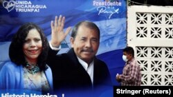 Muškarac prolazi pored predizbornog plakata na kojem su Rozario Muriljo i Danijel Ortega, Managva, 2. novembar