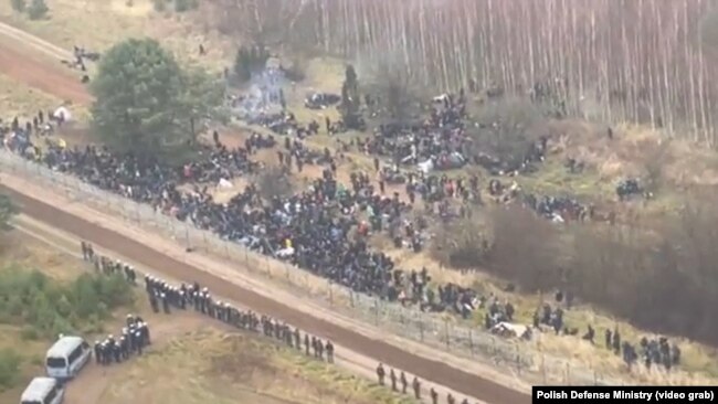 Fotografi e marrë nga një video ku shfaqen qindra migrantë në kufirin ndërmjet Polonisë dhe Bjellorusisë.