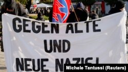 Demonstranti u nemačkom gradu Gubenu sa transparentom na kojem piše "Protiv starih i novih nacista", 23. oktobar 2021. 