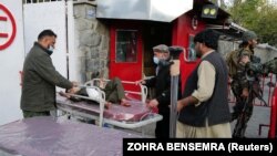 Мальчик, пострадавший во время взрыва, лежит на носилках у входа в больницу в Кабуле
