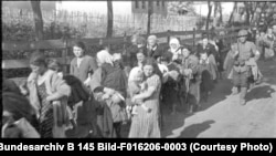 Румынский солдат конвоирует группу еврейских женщин и детей, предназначенных для депортации. Юг Украины, 1941 год