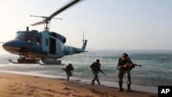 In this photo released by the Iranian Army on November 7, troops participate in a maneuver in a coastal area in southeastern Iran.