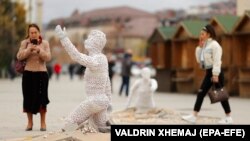 Ljudi šetaju između skulptura umetničke instalacije kosovskog vajara Erola Muratija pod nazivom "Pronađi me" postavljenim na glavnom trgu u Prištini, Kosovo, 9. novembra 2021.