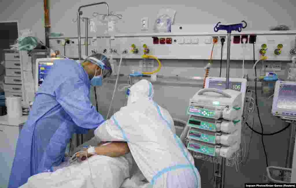 Работники Института пневмологии имени Мариуса Насты в Бухаресте поправляют дыхательную маску на лице пациента с коронавирусом