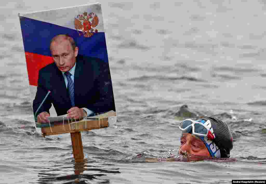Egy férfi úszik Vlagyimir Putyin születésnapjának tiszteletére az Ob folyóban Barnaulban