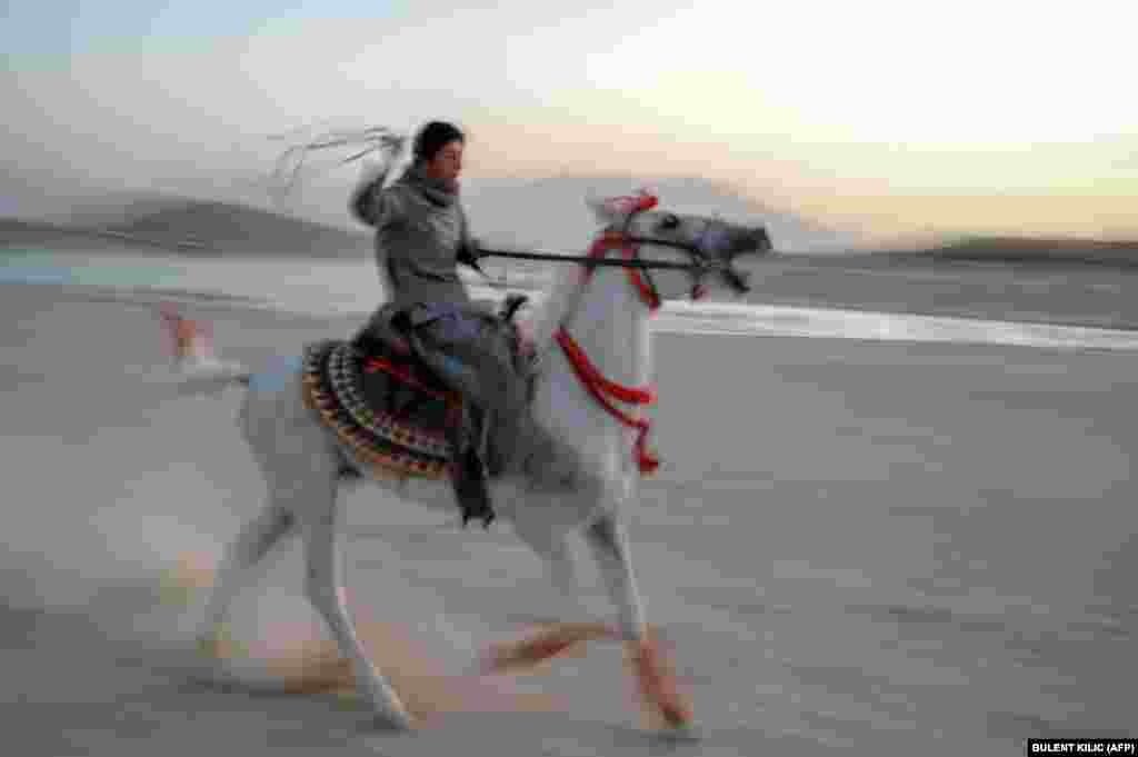 A boy rides a horse next to the Qargha Reservoir on the outskirts of Kabul.