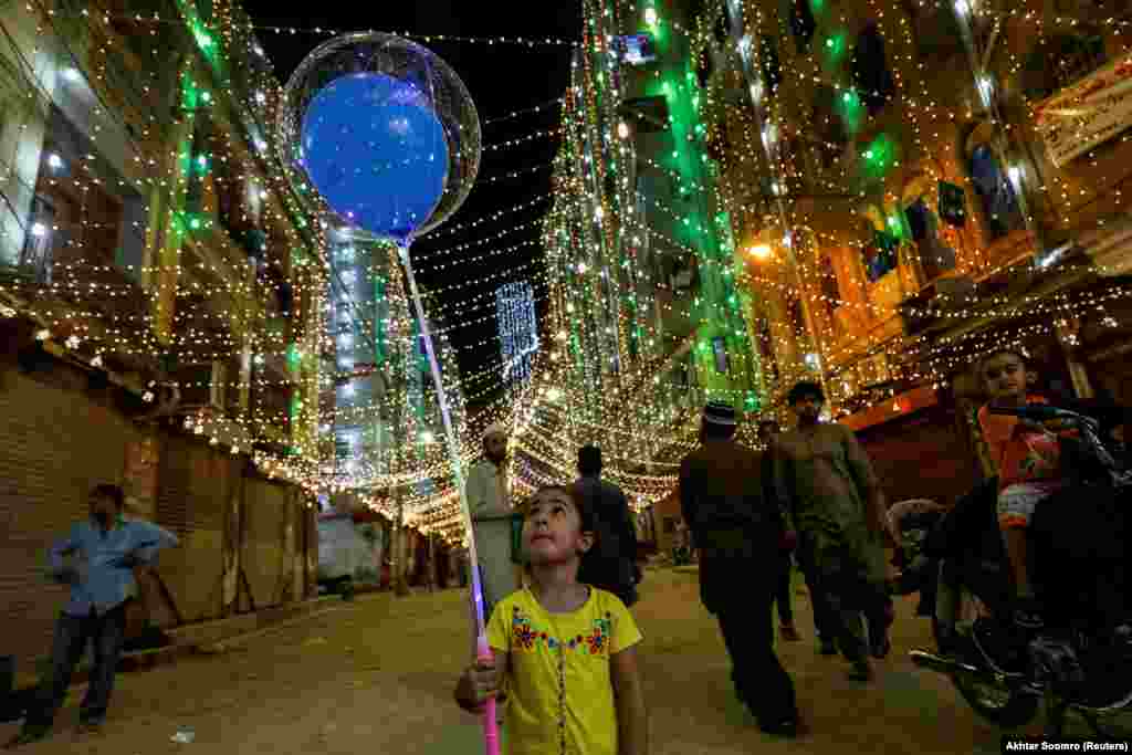 Девушка с воздушными шарами идет накануне празднования дня рождения пророка&nbsp;Мухаммеда в Карачи, Пакистан, 18 октября