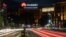 Cars drive past a Huawei logo on a building in central Belgrade.