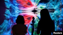 Vizitorët shikojnë instilacionin e artit të titulluar: "Makina e halucinacioneve - Hapësira: Metaverse" në Hong Kong më 30 shtator 2021.
