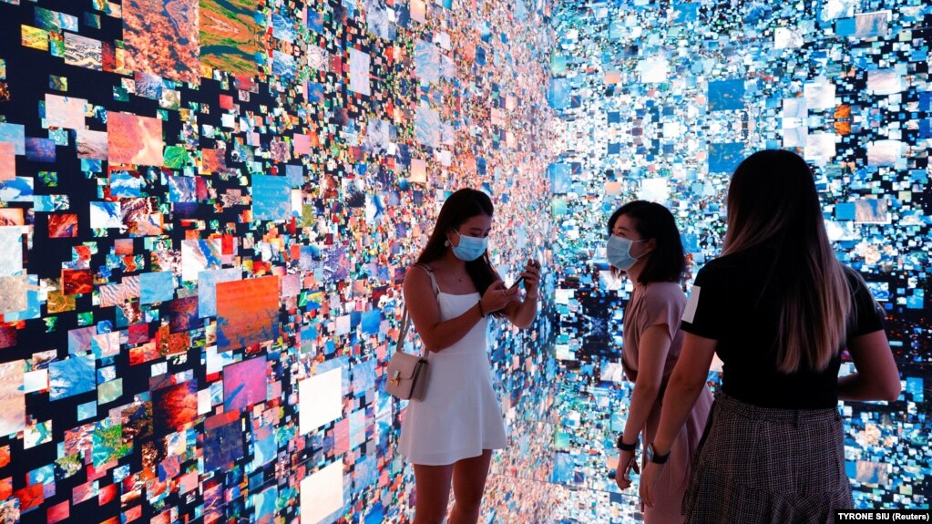بازدیدکنندگان در مقابل یک چیدمان هنری چندبعدی با عنوان «توهمات ماشینی - فضا: متاورس»، هنگ‌کنگ، ۲۰۲۱