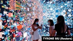 Vizitorët shikojnë instilacionin e artit të titulluar: "Makina e halucinacioneve - Hapësira: Metaverse" në Hong Kong më 30 shtator 2021.