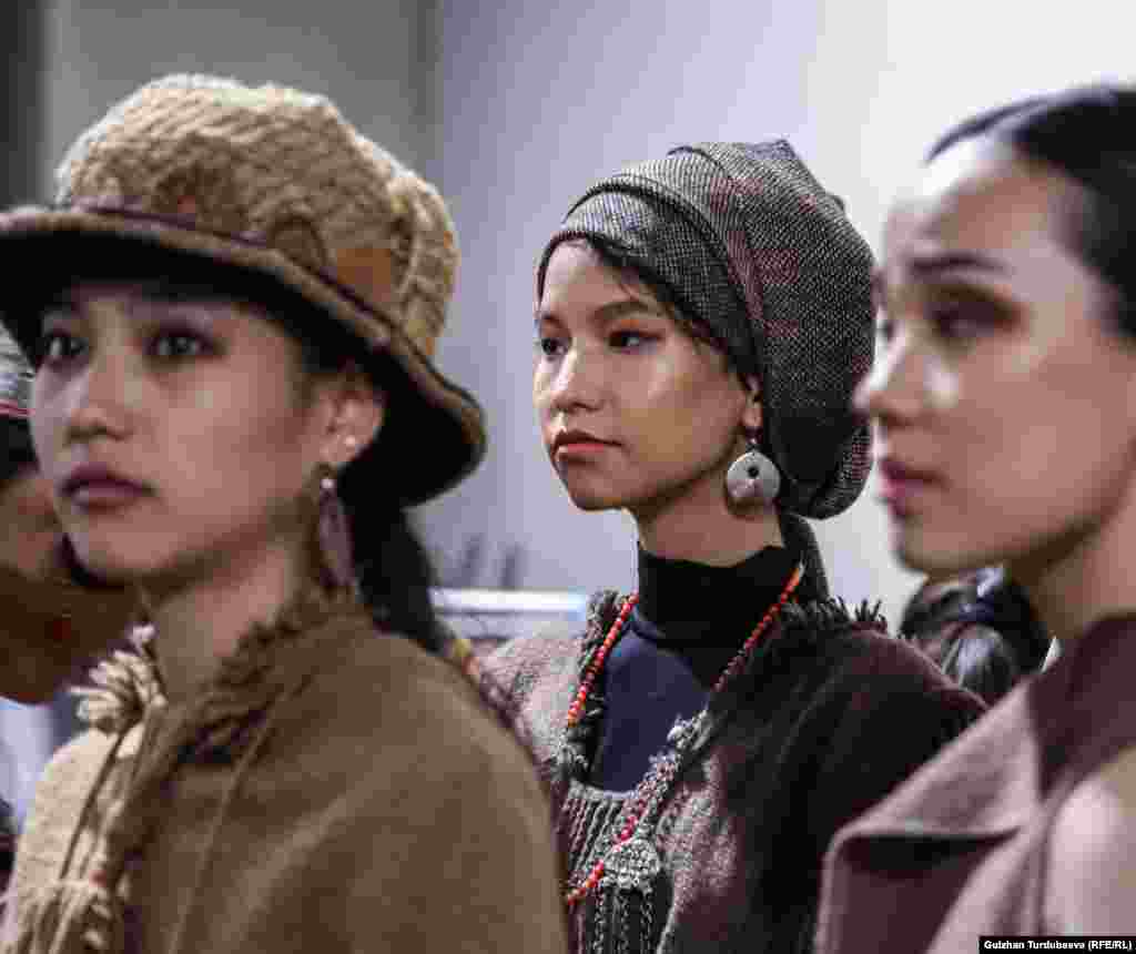 Кыргызстанский дизайнер Гульмира Акматова представила коллекцию в коллаборации с казахстанской коллегой - дизайнером Севой. Шерстяную одежду преимущественно серого цвета украшают необычные головные уборы от Севы.
