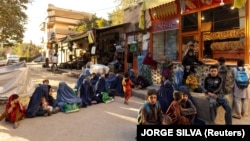 گروهی از زنان و کودکان در مقابل یک نانوایی در کابل صف بسته اند تا بتوانند نان خیرات یا رایگان دریافت کنند.