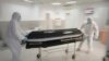 Virus Outbreak Romania -- Funeral house employees remove the coffin of a COVID-19 victim from the University Emergency Hospital morgue in Bucharest, Romania, Monday, Nov. 8, 2021. Over the past weeks Romania reported record numbers of daily new infections