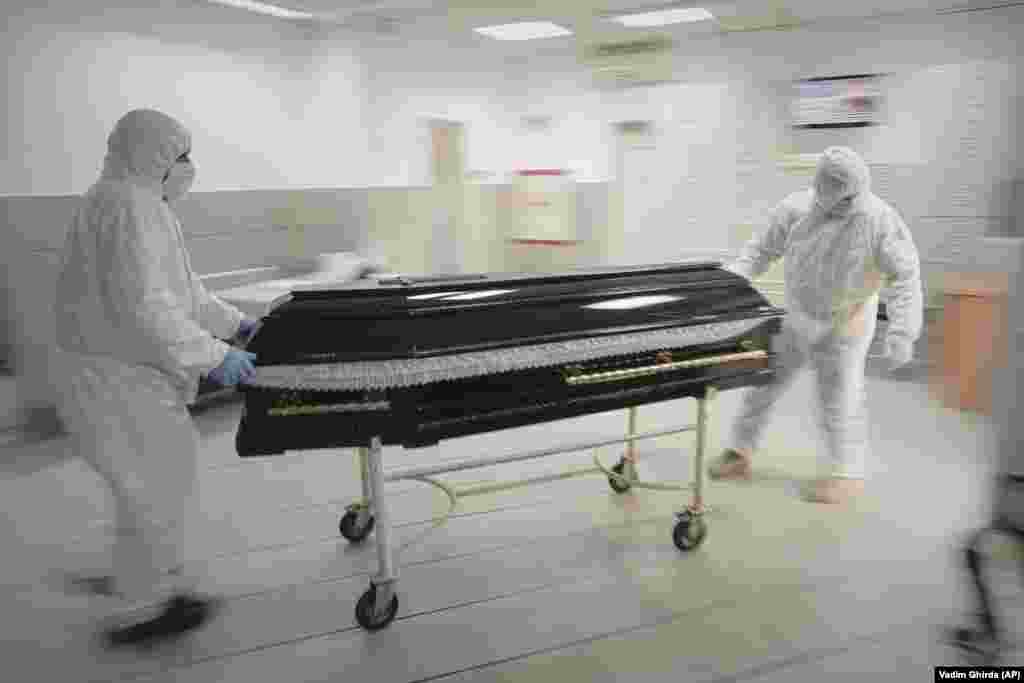 Funeral home employees remove the coffin of a COVID-19 victim from a morgue in Bucharest amid record coronavirus infection rates in Romania.