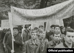 Кадр из фильма. На плакате надпись: "Любое насилие – это фашизм. Русские, убирайтесь домой"