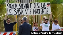 Grupa demonstranata ispred suda u Palermu drži baner na kom piše "Gospodine Salvini, tako spašavate nedužne živote?", 23. oktobar 2021. 