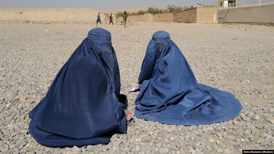 Displaced Afghan women wait to receive aid from the UNHCR on the outskirts of Kabul in October.