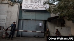 Taliban fighters stand guard at the entrance to the former Ministry of Women Affairs, which the Taliban replaced with the Ministry for the Propagation of Virtue and Prevention of Vice.