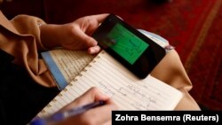 Sahar, 17, an 11th grader, studies on YouTube to keep herself busy at her home in Kabul on October 19.
