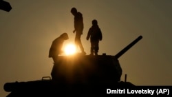 Copii jucându-se pe un tanc din epoca sovietică T-34 cu țeava îndreptată către Nistru, instalat ca monument la Tiraspol (duminică, 31 octombrie, 2021, AP Photo/Dmitri Lovetsky)
