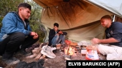 Afghans prepare food at an improvised camp in northern Bosnia in October 2021.