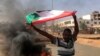 Чоловік із національним прапором Судану під час акції протесту проти військового перевороту, Хартум, 25 жовтня 20212 року