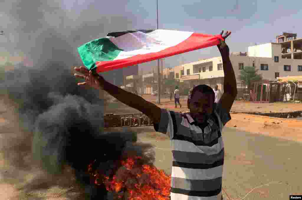 Demonstrant maše zastavom tokom onoga što je Ministarstvo informisanja nazvalo vojnim udarom, Kartum, Sudan, 25. oktobra 2021.