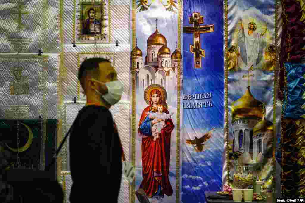 Посетител поминува покрај изложбата на верски транспаренти на изложбата. Поради порастот на смртните случаи од коронавирус, изложбата во Москва ќе биде затворена порано како дел од националното заклучување во Русија.