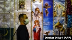 A visitor walks past a display of religious banners at the exhibition.