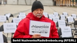 Письменник Андрій Курков під час правозахисної акції «Порожні стільці» на підтримку українських політв'язнів у Росії та окупованому Криму, а також полонених в ОРДЛО. Київ, Софійська площа, 15 листопада 2021 року