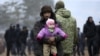Migráns férfi gyermekével a belarusz–lengyel határon felállított táborok egyikében, Hrodna térségében 2021. november 14-én