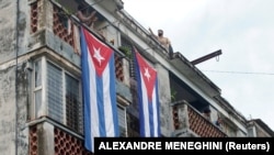 Окна Юниора Гарсии, закрытые кубинскими флагами