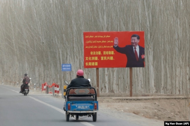 Глава Китая Си Цзиньпин на рекламном щите с лозунгом об управлении Синьцзяном. Синьцзян-Уйгурский автономный район, 21 марта 2021 года