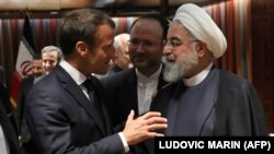 French President Emmanuel Macron (L) and Iranian President Hassan Rouhani speak at the United Nations headquarters on September 23, 2019, in New York. 