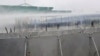 A lengyel védelmi minisztérium videójának képernyőképén a lengyel biztonságiak vízágyút vetnek be a belarusz határt átlépni próbáló migránsok ellen a Kuźnica–Bruzgi átkelőnél 2021. november 16-án