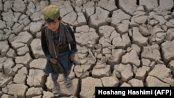 A boy stands on desiccated land in Badghis Province, Afghanistan, which is currently experiencing one of its worst droughts and food shortages in decades. 